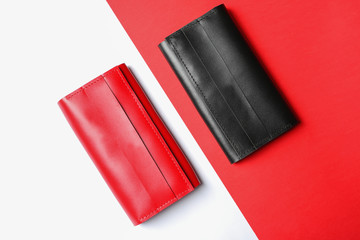 Stylish wallets on color background, top view