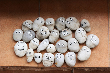 Stone decor for garden. Stones with funny faces. Allegory on society, group, friendship and teamwork