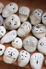 Obraz premium Stone decor for garden. Stones with funny faces. Allegory on society, group, friendship and teamwork