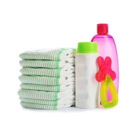 Stack of diapers and baby accessories on white background