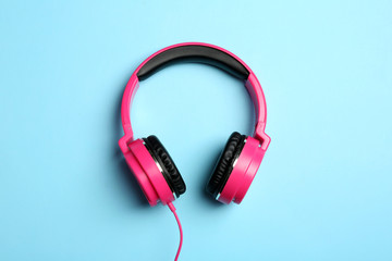 Stylish headphones on color background, top view