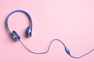 Stylish headphones on color background, top view. Space for text