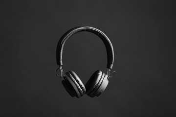 Stylish headphones with pads on black background