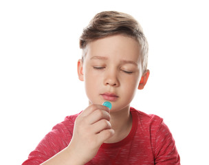 Little child taking pill on white background. Danger of medicament intoxication