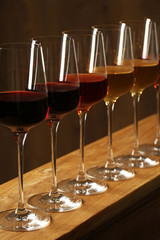 Glasses of different wines against blurred background. Expensive collection