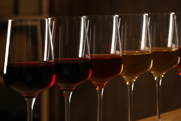 Glasses of different wines against blurred background, closeup. Expensive collection