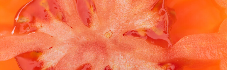 Fototapeta premium close up view of red ripe tomato half with seeds, panoramic shot