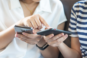 A beautiful Asian woman uses a smartphone in the city center to search for various places. Restaurant reviews And send a message with copy space.