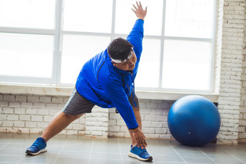 Fat men are exercising in the house.