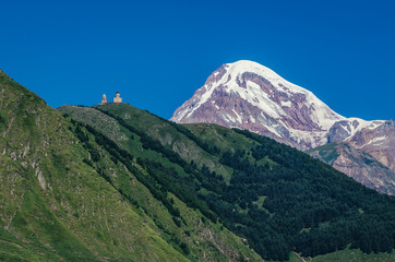 Kazbek Mountain in Caucasus Mountains, Georgia. View with one of the foremost Georgian landmarks - Tsminda Sameba church