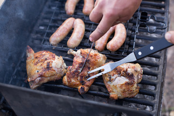 Summer barbecue, grilling sausages and chicken