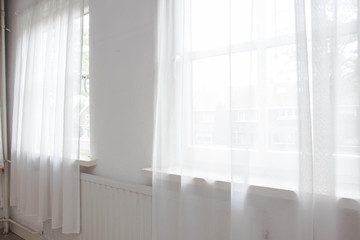 White net curtain against two windows in a house,