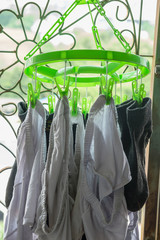 Green clothespin, socks clamp and white pants Dry clothes on the balcony
