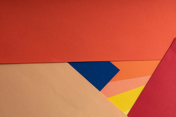 Sheets of colored paper are on the table. Paper of blue, yellow, green, blue, red, coral and peach colors. Abstract creative background