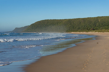 Fototapeta na wymiar Empty sand beach landscape with waves and sand with footprints