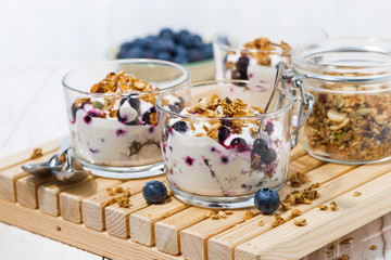 glasses with healthy breakfast with blueberries, yogurt and granola