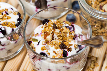 glasses with healthy dessert with blueberries, yogurt and muesli, top view closeup
