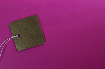 gold square paper tag on pink background