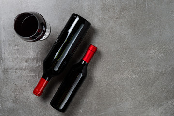 Naklejka premium Two bottles of wine glass on concrete background. Copy Space.