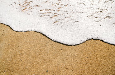 Ocean wave on sandy beach background