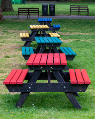 Different coloured tables and seats in a park