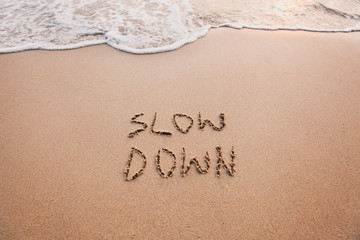 slow down, mindfulness concept written on sand - obrazy, fototapety, plakaty