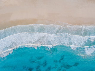 Fototapeta na wymiar Aerial view of sand beach, ocean texture background looping, top down view of sea waves by drone.
