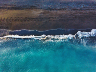 blue ocean wave on black sand beach, water surface aerial view landscape top down, Iceland...