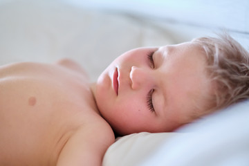 Three year old toddler boy sleeping on pillow