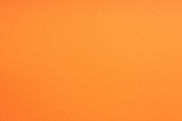 Paper background orange color. Rough paper texture. Closeup. Macro.