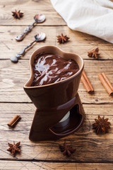 Chocolate paste with cinnamon and anise. Fondue with chocolate on a wooden table. copy space