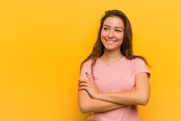 Young european woman isolated over yellow background smiling confident with crossed arms.