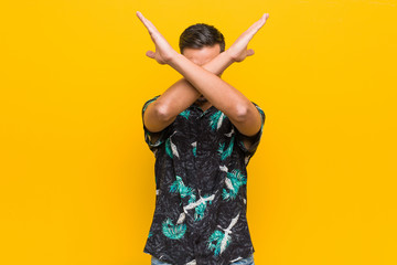 Young filipino man wearing summer clothes keeping two arms crossed, denial concept.