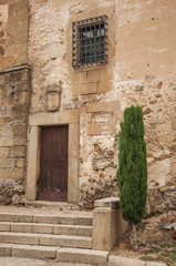 Wooden door in old stone building and staircase in Plasencia