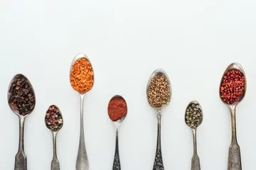 Poster top view of colorful spices in silver spoons on white background with copy space © LIGHTFIELD STUDIOS