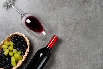 Basket with grapes and wine glass on concrete background. Copy Space.