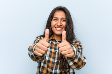 Young cool indian woman with thumbs ups, cheers about something, support and respect concept.