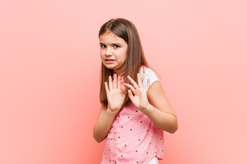 Cute little girl rejecting someone showing a gesture of disgust.