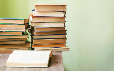 On the table a stack of old books. Preparation for exams at the University. Reading literature.
