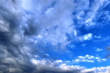 Calm and beautiful mixed fluffy cloud formations on a stunning deep blue sky