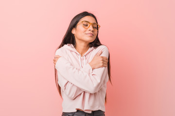 Young pretty arab woman wearing a casual sport look hugs, smiling carefree and happy.