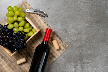 Wooden box with grapes bowl with wine on concrete background. Copy space.