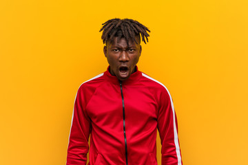 Young fitness black man screaming very angry and aggressive.