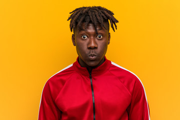 Young fitness black man blows cheeks, has tired expression. Facial expression concept.