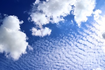Calm and beautiful mixed fluffy cloud formations on a stunning deep blue sky