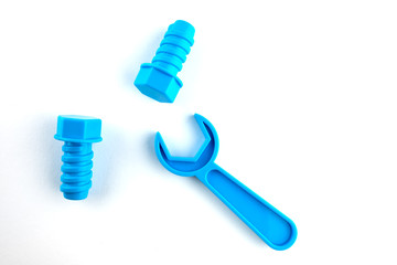 Children's toys on a white background, blue wrench, two blue bolts. Tools for repair. Game concept. Place for text.