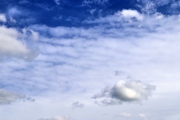 Calm and beautiful mixed fluffy cloud formations on a stunning deep blue sky