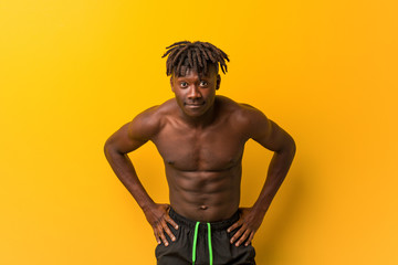 Fototapeta premium Young black man shirtless wearing swimsuit scolding someone very angry.