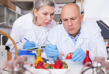 Scientists taking notes while performing experiments