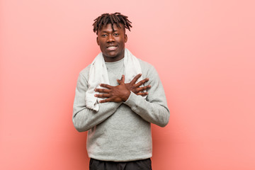 Obraz premium Young fitness african black man has friendly expression, pressing palm to chest. Love concept.